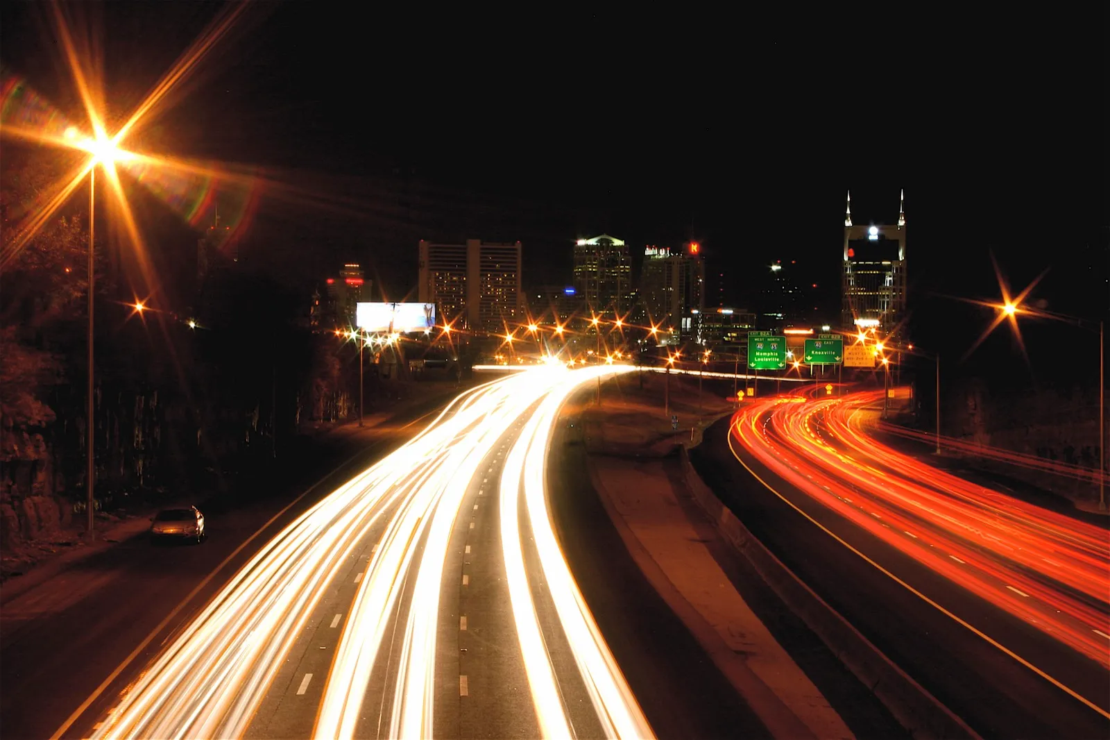 Vista nocturna del centro de Nashville, Tennessee, con estelas de luz de los autos en la autopista