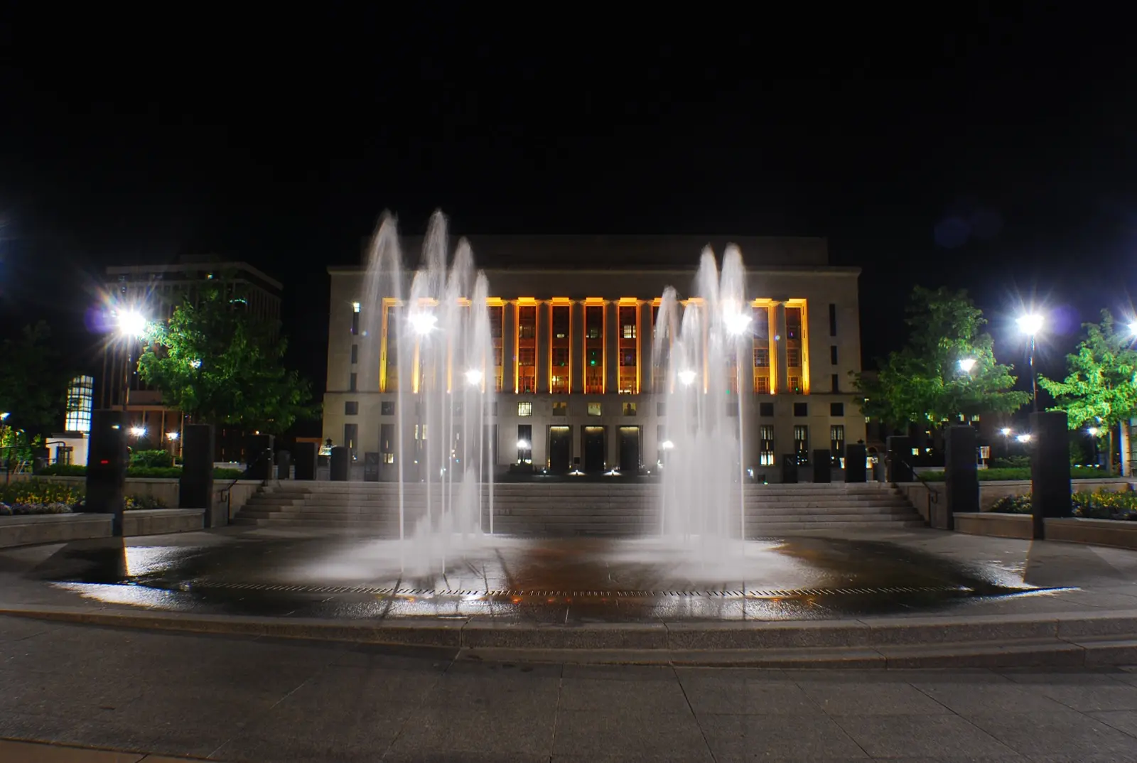 Fachada iluminada del Davidson County Courthouse, en Nashville, de noche, con una fuente en primer plano