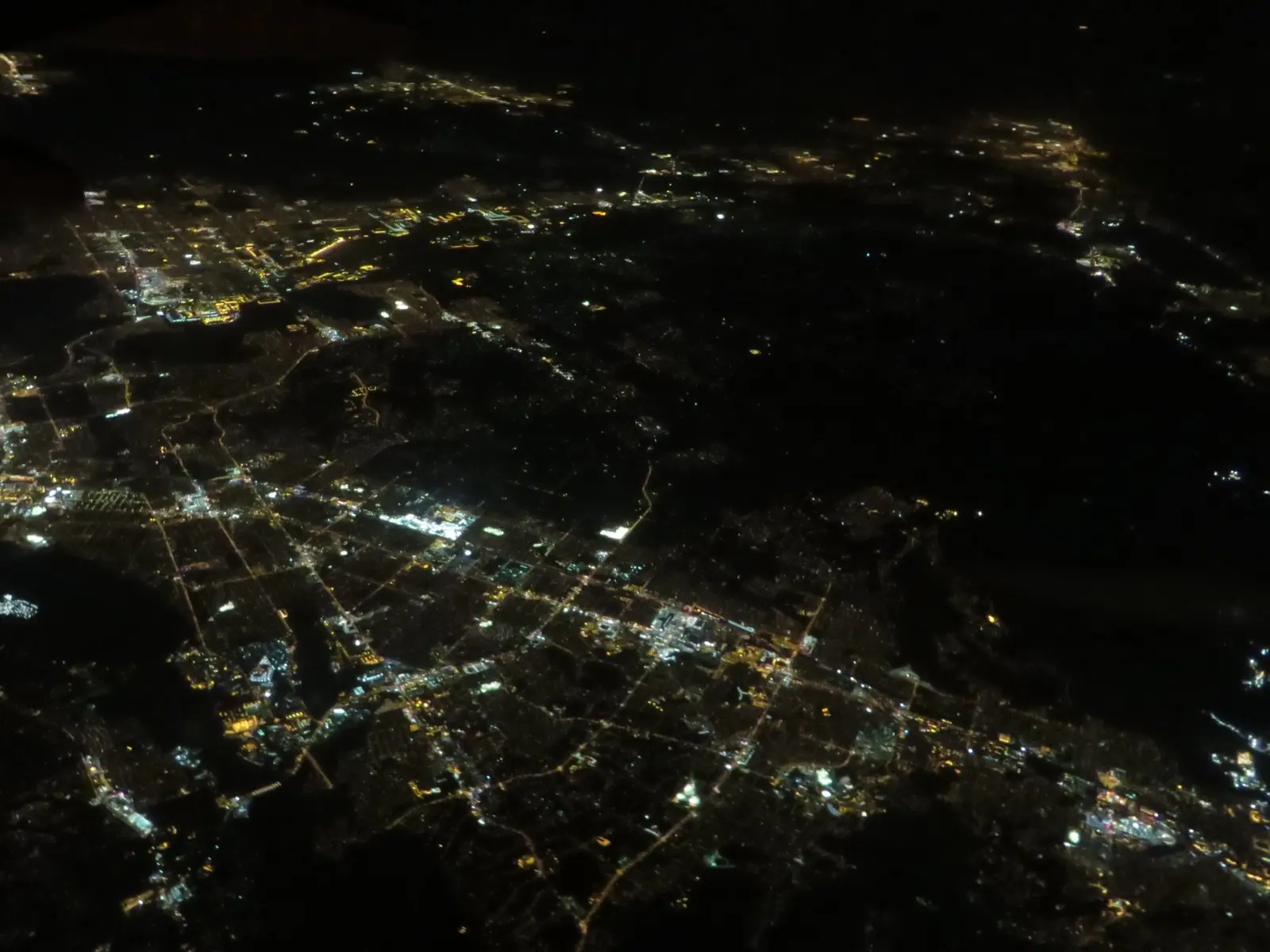 Vista aérea nocturna del Inland Empire, en el sur de California, con luces de calles y edificios sobre un fondo oscuro