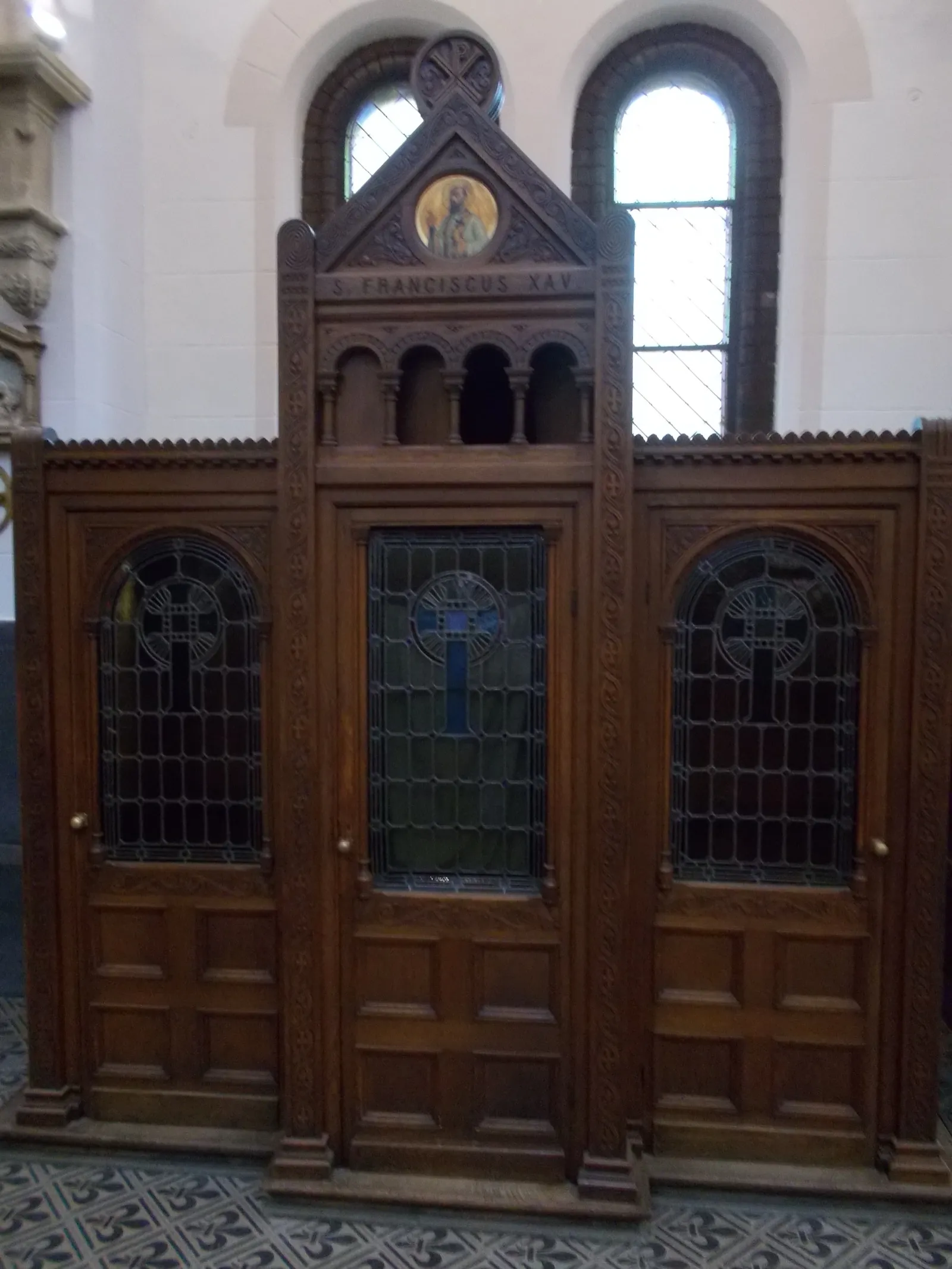 Puerta de un confesionario de madera con vitrales