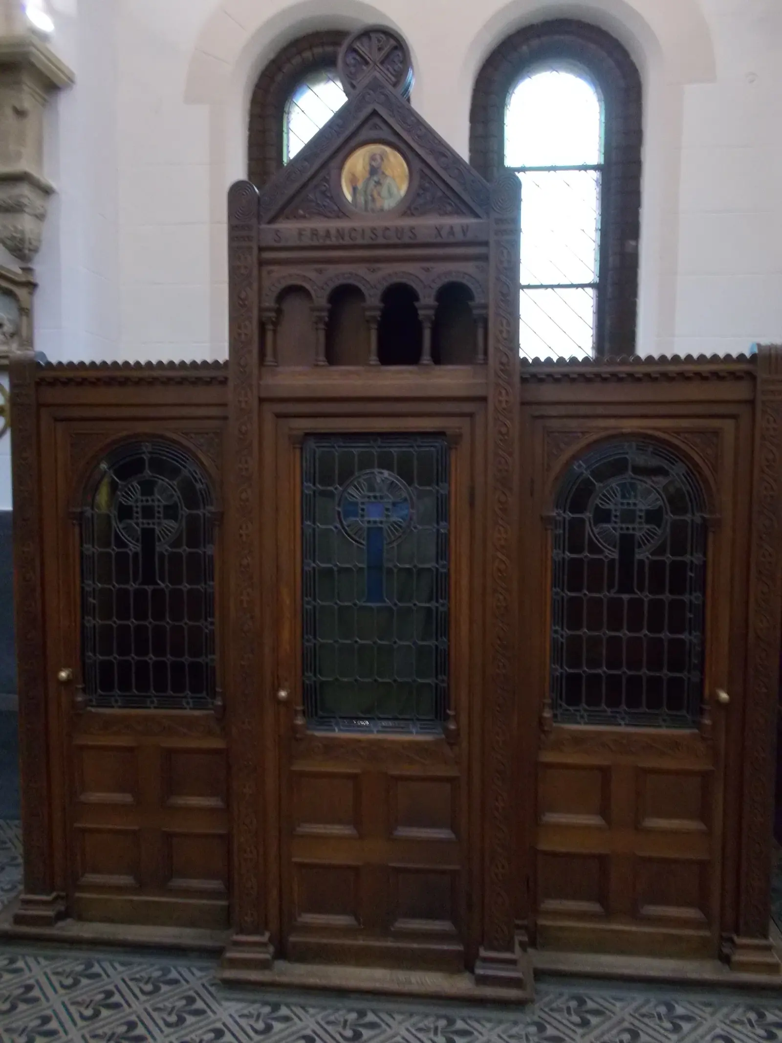 Puerta de un confesionario de madera con vitrales