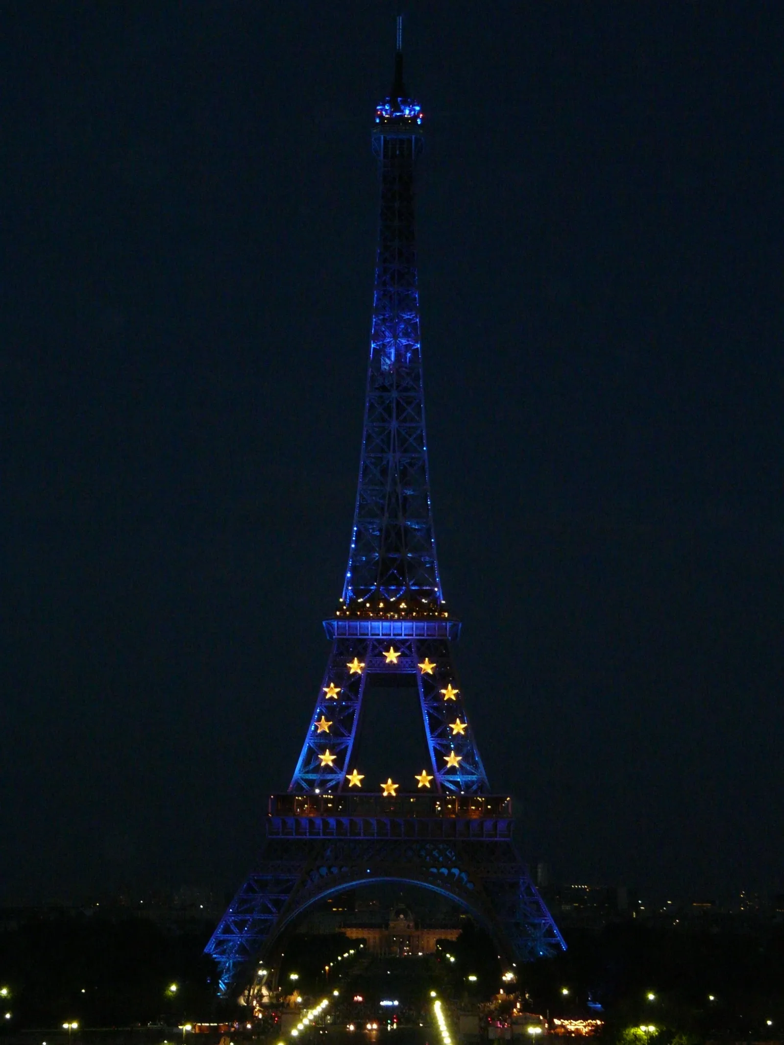 La Torre Eiffel iluminada de noche con las estrellas de la bandera de la Unión Europea