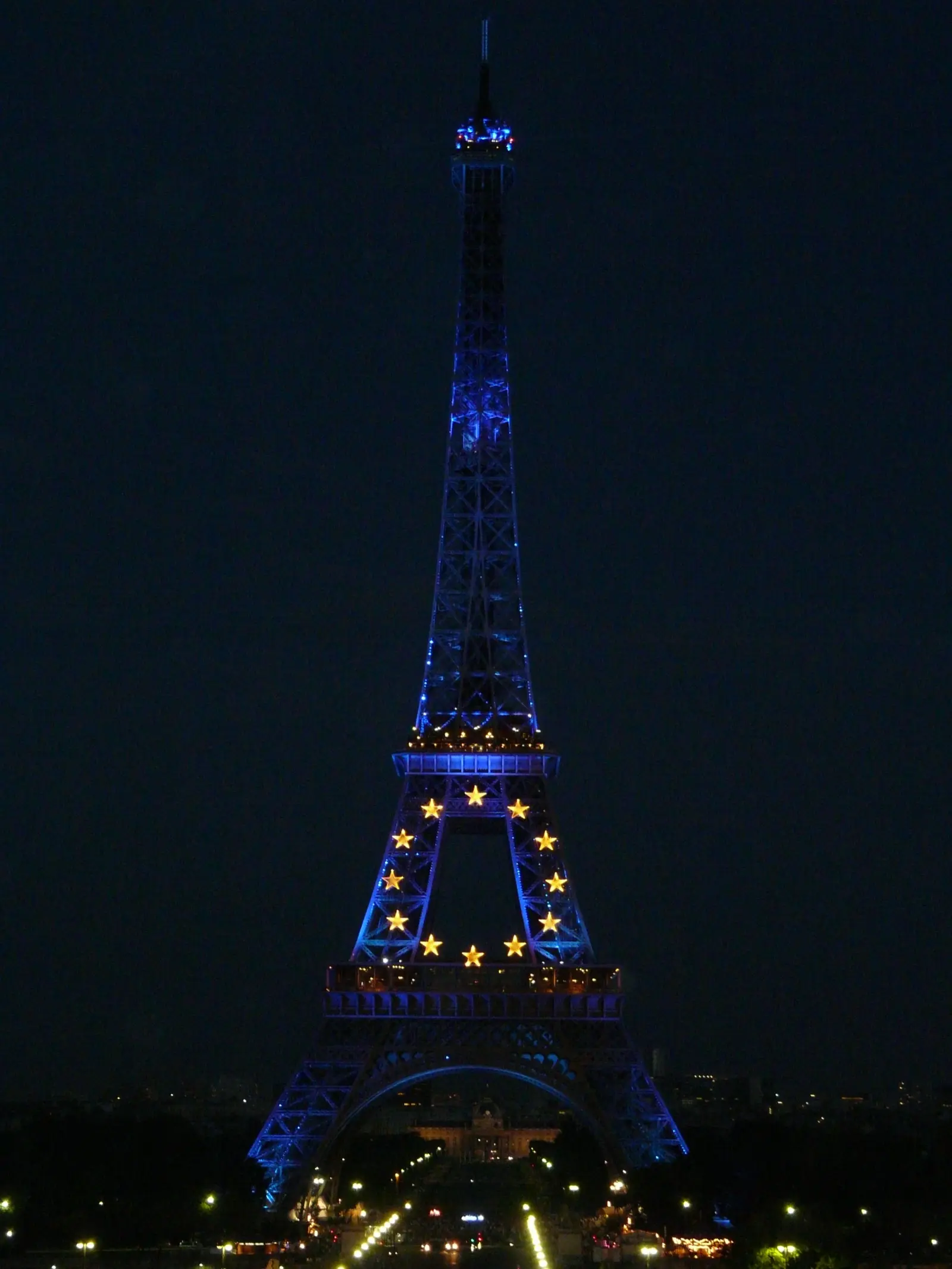 La Torre Eiffel iluminada de noche con las estrellas de la bandera de la Unión Europea