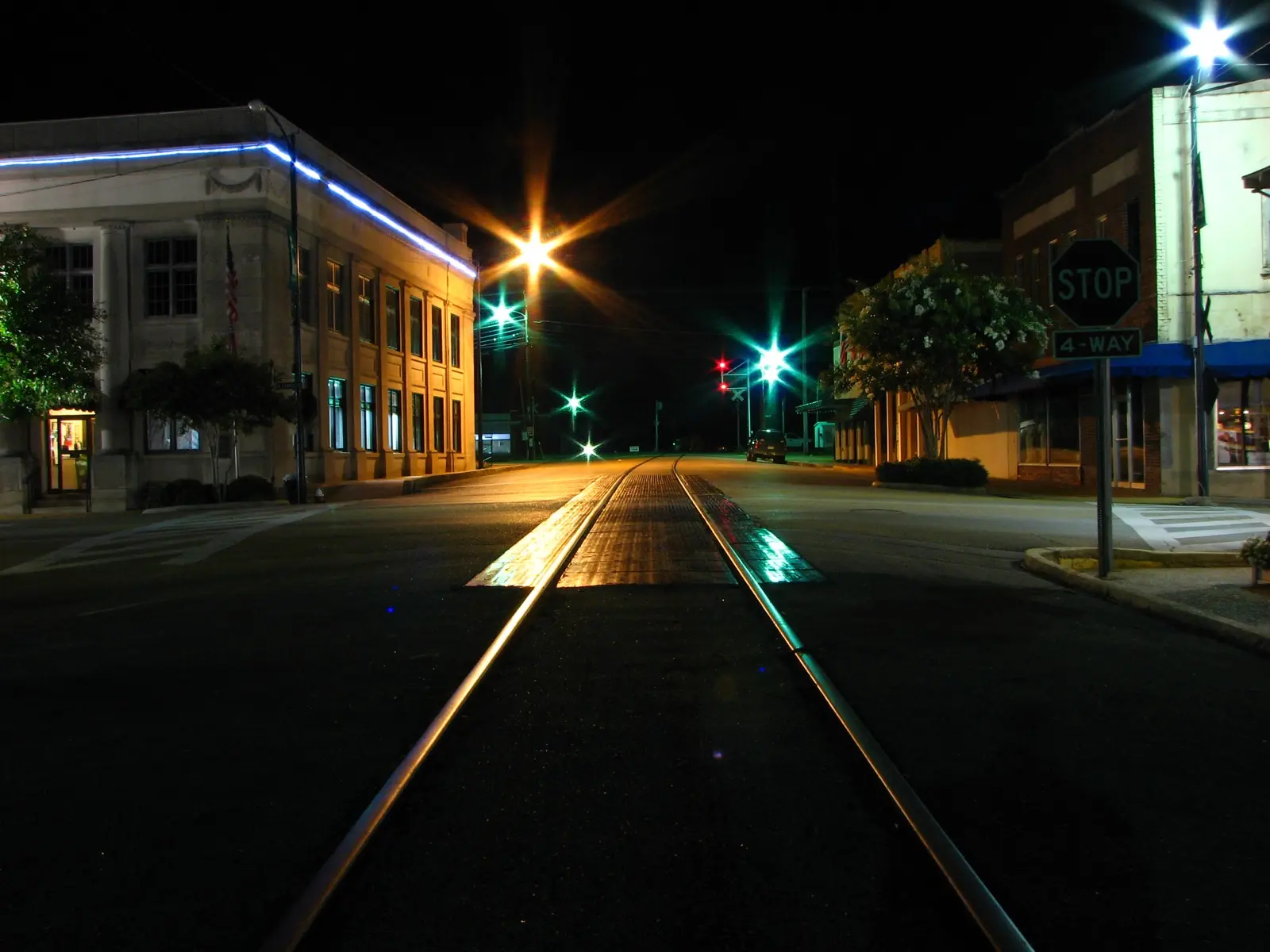 Vías de tren cruzando una calle de un pueblo de Estados Unidos de noche