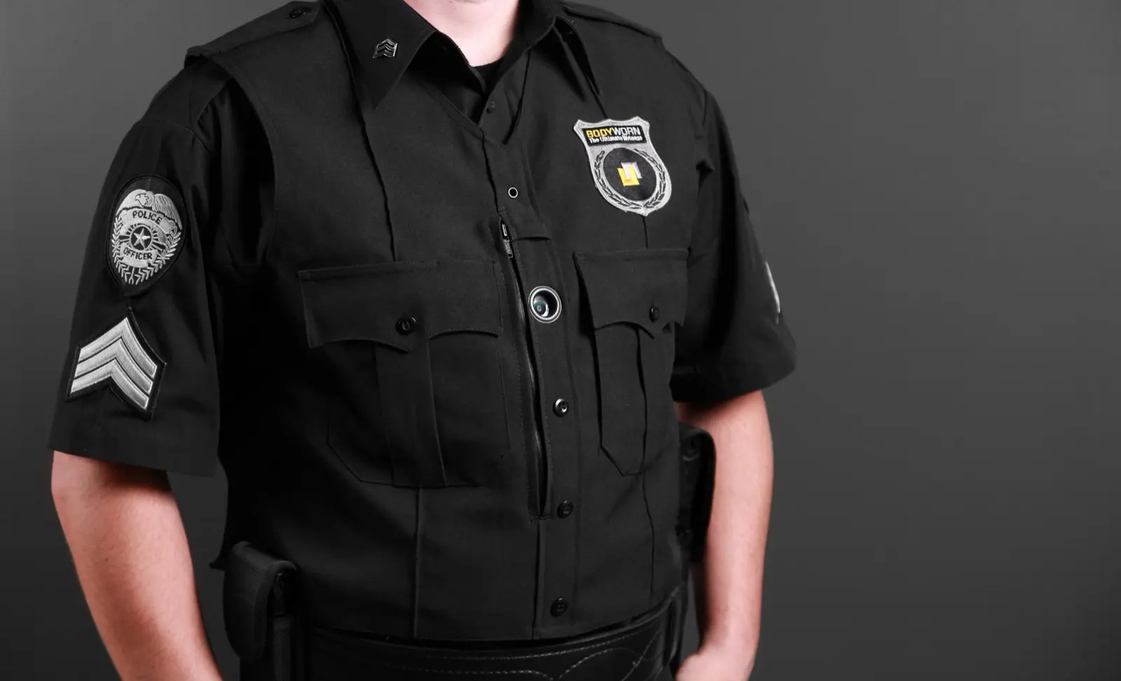Primer plano de la lente de una cámara corporal sobre el pecho de un uniforme negro