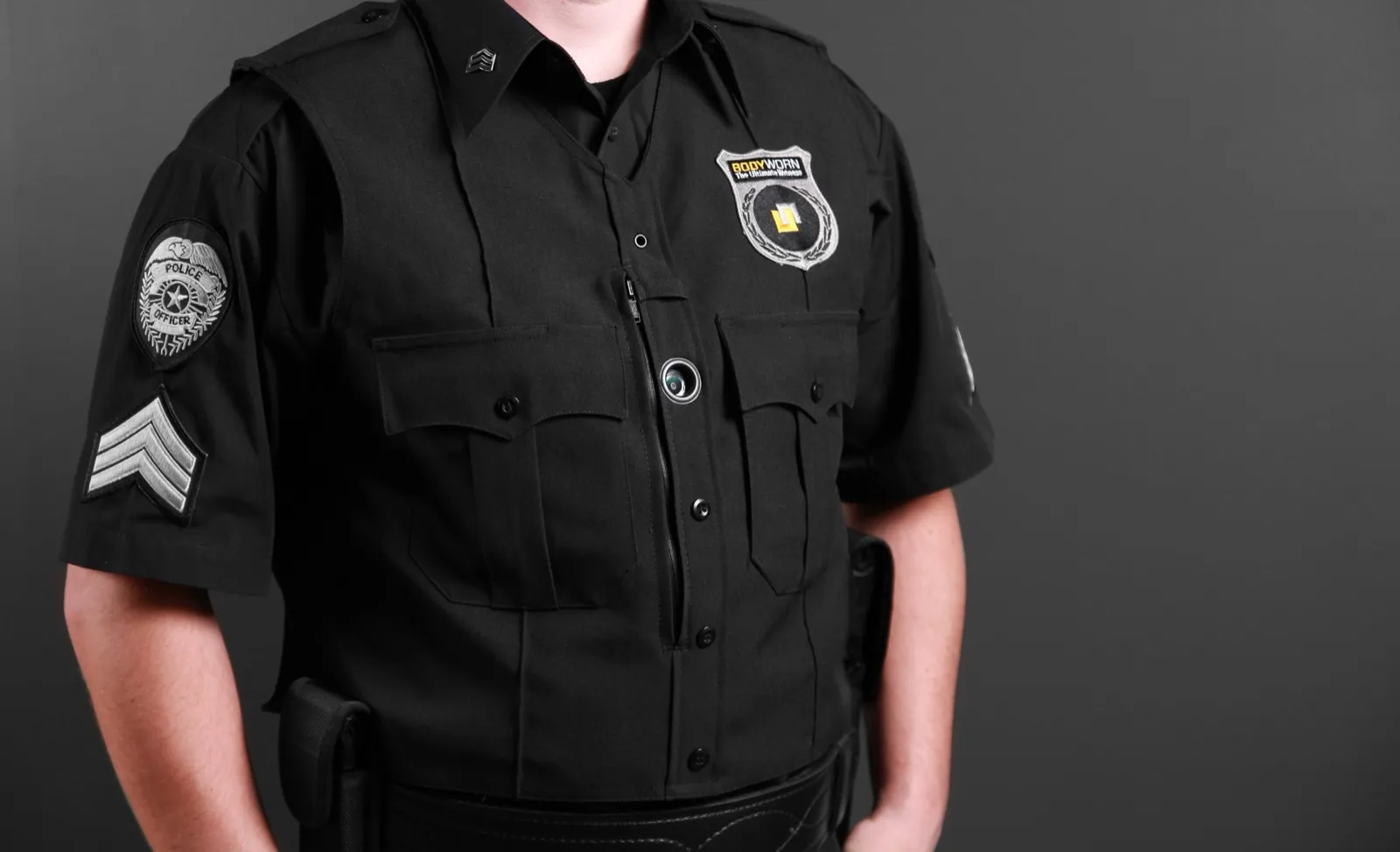 Primer plano de la lente de una cámara corporal sobre el pecho de un uniforme negro