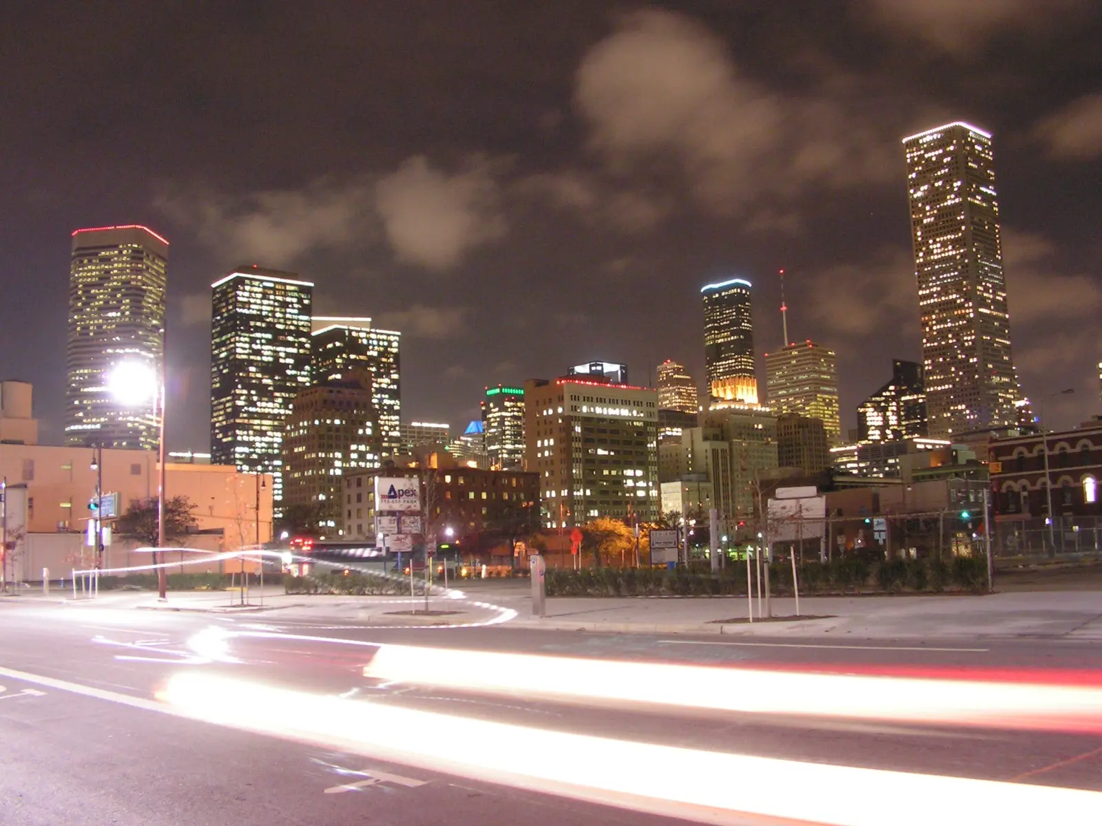 Edificios del centro de Houston de noche, con estelas de luz de vehículos en la calle (imagen de referencia)