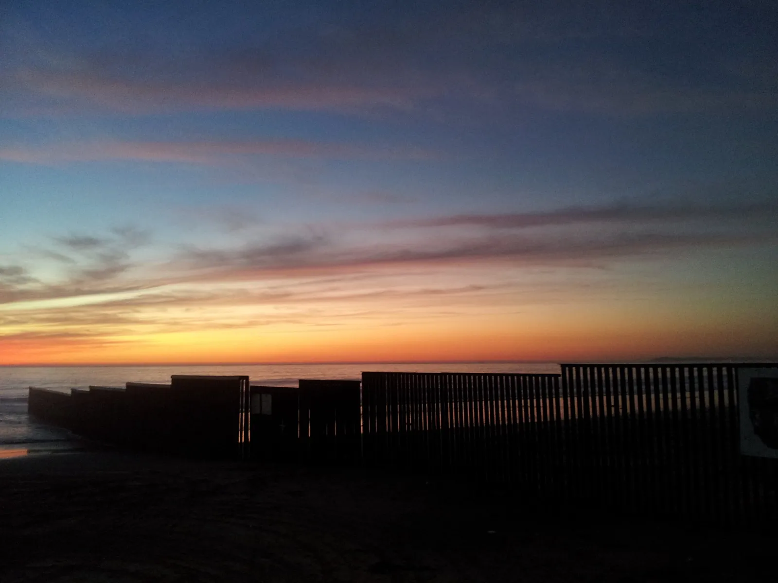 Atardecer sobre la valla fronteriza en Playas de Tijuana, México