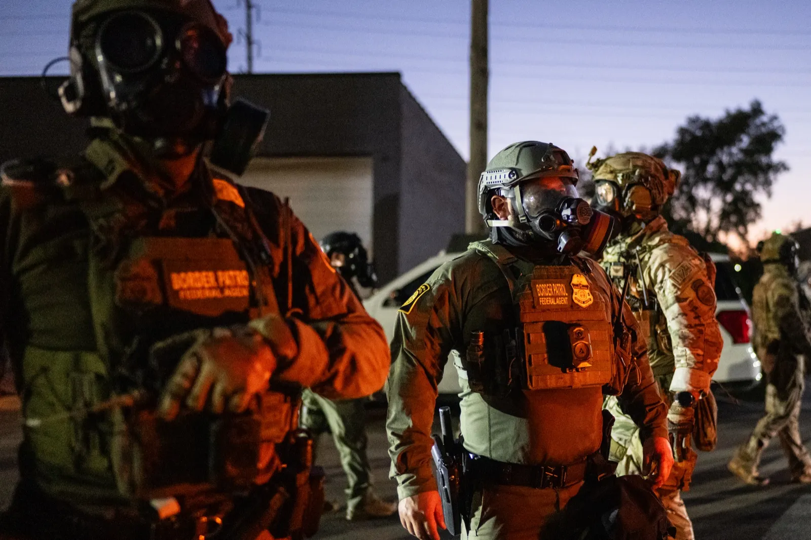 Agentes de la Patrulla Fronteriza con máscaras y chalecos al atardecer en Broadview, Illinois