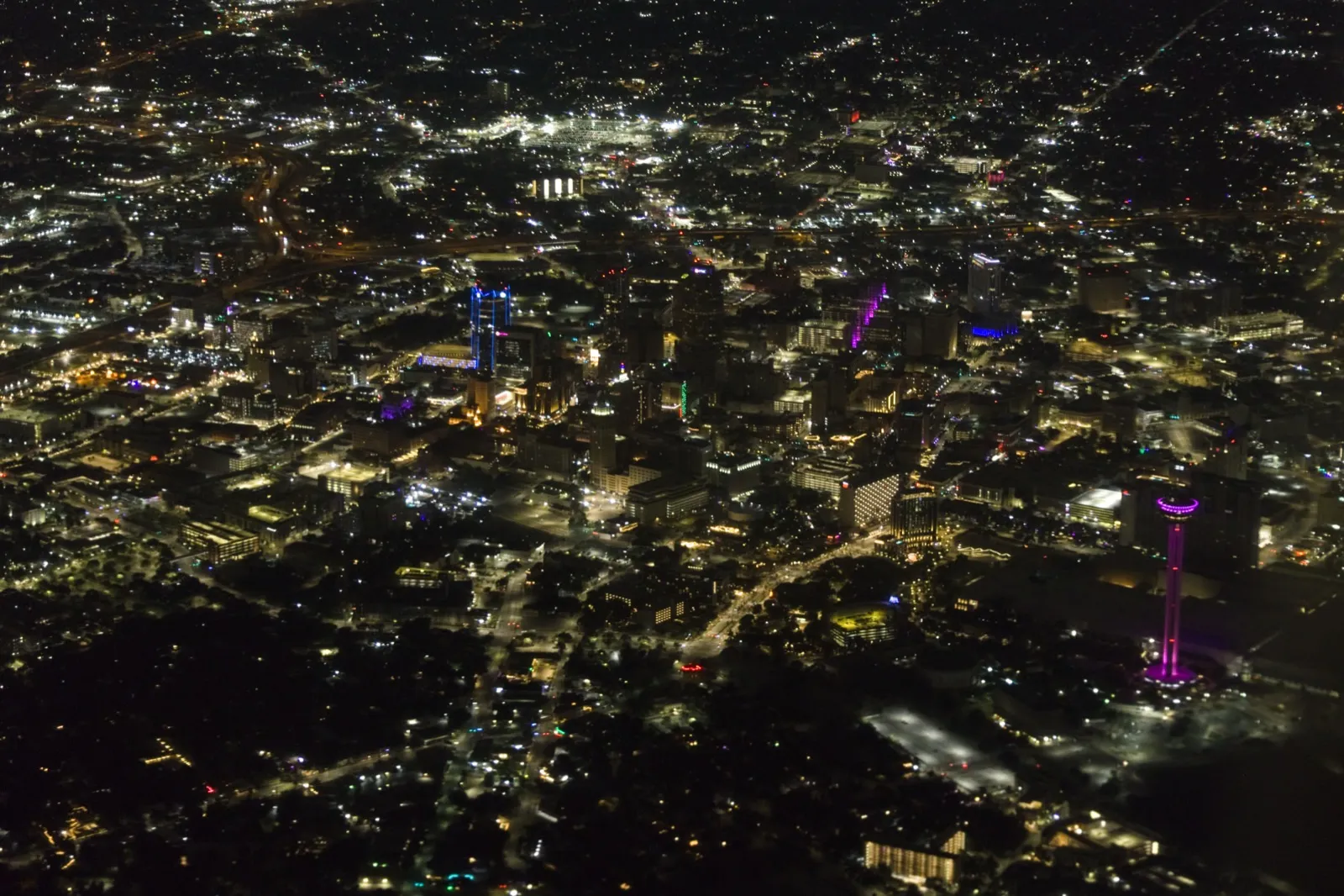 Vista aérea nocturna del centro de San Antonio, Texas, con la Torre de las Américas iluminada