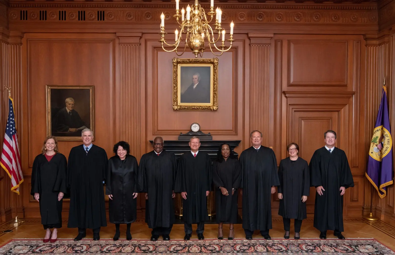 Los nueve jueces de la Corte Suprema de EE. UU., con toga negra, de pie frente a una chimenea, entre ellos Sonia Sotomayor y Neil Gorsuch